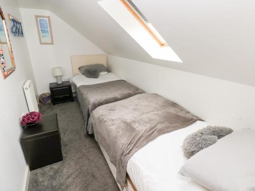 a attic bedroom with two beds and a skylight at Barn 2 in Swansea