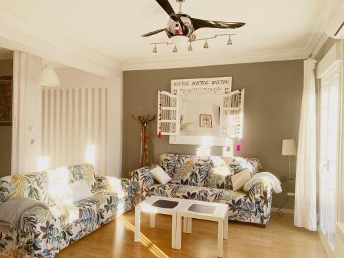 a living room with a couch and a ceiling fan at Un hogar en el centro - La Casa de Ion Parking gratuito in Zaragoza