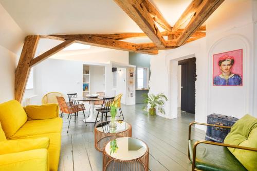 a living room with a yellow couch and a table at Le Grand Amerval in Nancy