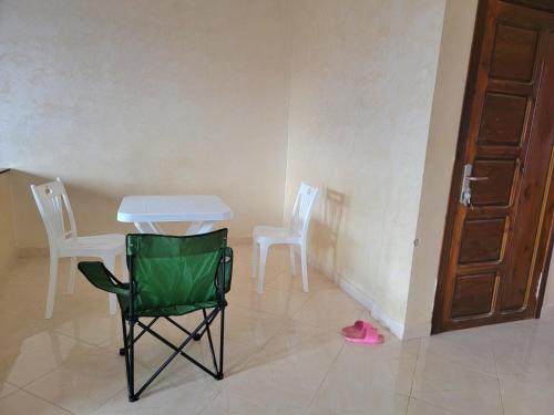 Habitación con mesa, 2 sillas y puerta en Appartement de luxe Nour, en Fez