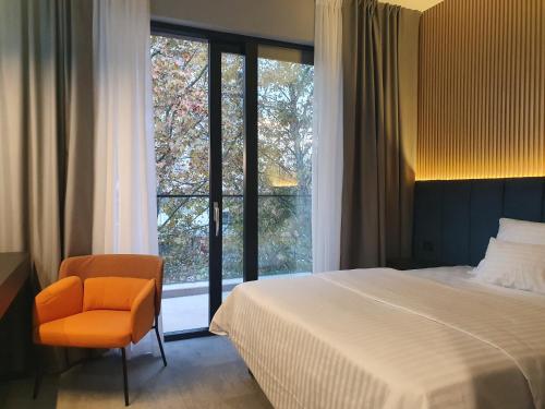 a bedroom with a bed and a chair and a window at Avenue21 in Zagreb