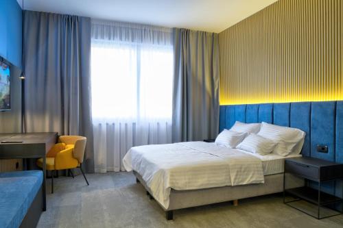 a bedroom with a bed and a desk and a window at Avenue21 in Zagreb