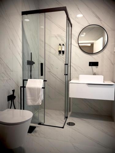 a bathroom with a shower and a toilet and a sink at BLUE ANCORA HOTEL in Vila Praia de Âncora