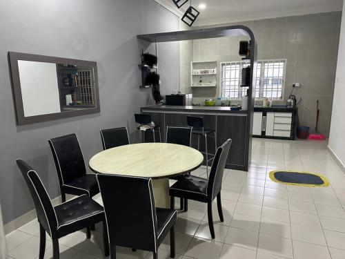 a kitchen with a table and chairs in a room at Homestay Triang in Kampong Kerayong