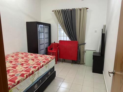 a bedroom with a red bed and a window at Homestay Triang in Kampong Kerayong