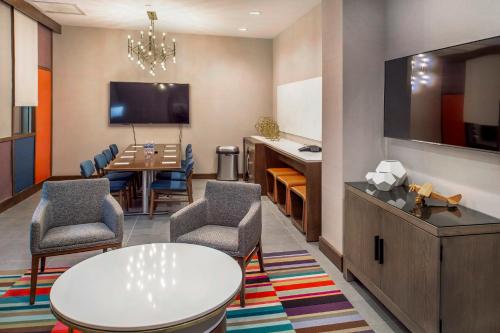 a waiting room with a table and chairs and a tv at Crowne Plaza Hotel St. Louis Airport by IHG in Bridgeton