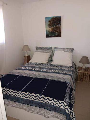 - un lit avec deux oreillers et une photo sur le mur dans l'établissement WEEK END A LA MER, à Fréjus