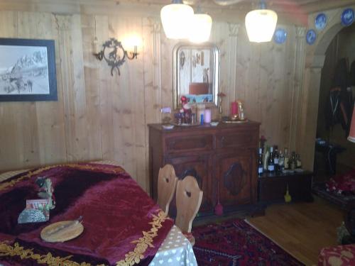 1 dormitorio con cama, tocador y espejo en Delizioso appartamento a Cortina, en Zuel