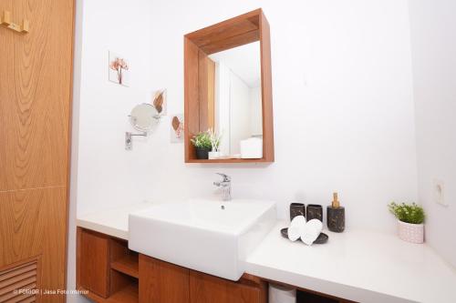 a bathroom with two sinks and a mirror at Villa Wezu Dago Village Bandung in Bandung