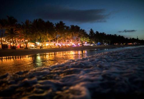 a beach at night with palm trees and lights at Viva Tangerine by Wyndham, A Trademark All Inclusive in Cabarete