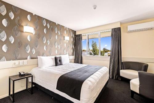 1 dormitorio con 1 cama, 1 silla y 1 ventana en Hotel Elms Christchurch, Ascend Hotel Collection en Christchurch