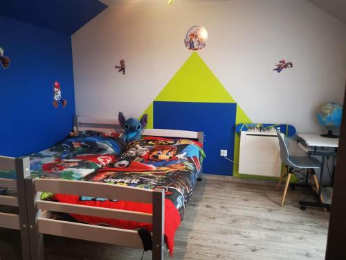 um quarto com uma cama com uma parede temática de Disney em Le Mans Fay sa course em Fay