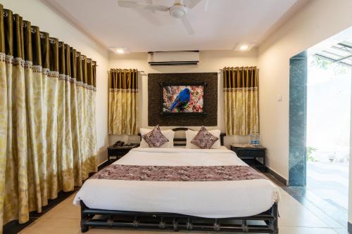 a bedroom with a large bed and curtains at Saavaj Resort in Sasan Gir