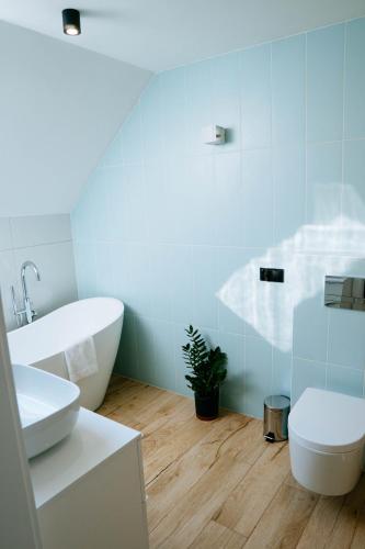 a bathroom with a tub and a toilet and a sink at THE VIEW - WILLA z basenem in Iława