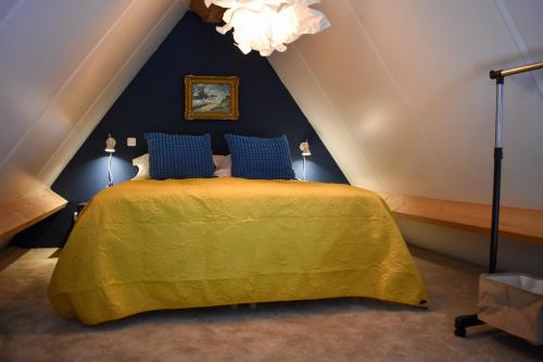 a bedroom with a yellow bed with blue walls at Stijlvol appartement 'Moto' in centrum Franeker. in Franeker