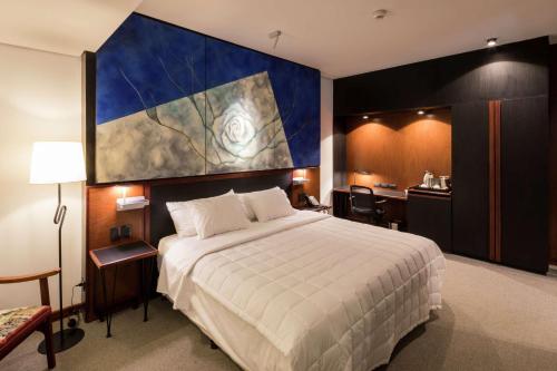 a hotel room with a large bed and a kitchen at Hilton Garden Inn Asuncion Aviadores Del Chaco in Asuncion