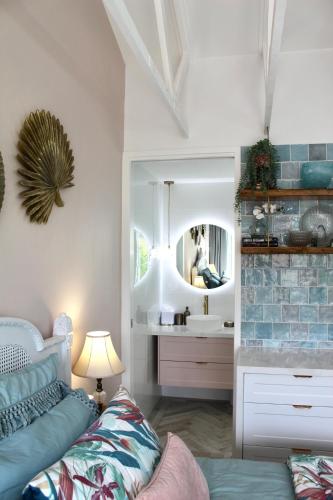 a room with a bed and a sink and a mirror at Sandpiper Studio in Scarborough