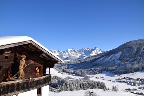 a cabin in the snow with a view of a mountain at Buttermilchalm in Sankt Martin am Tennengebirge