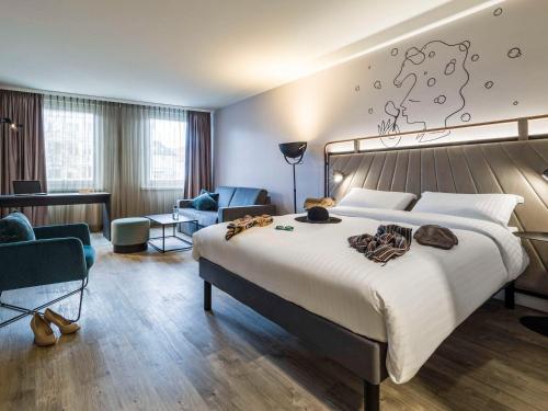 een hotelkamer met een groot bed en een bureau bij ibis Styles Bielefeld City in Bielefeld
