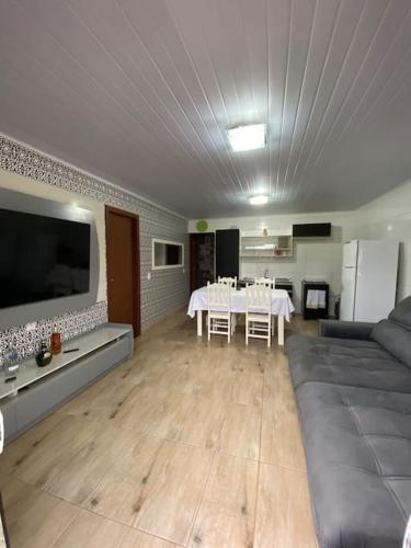 un grand salon avec une table et un canapé dans l'établissement Casa de Praia, à Palhoça