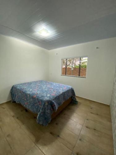 ein Schlafzimmer mit einem Bett in einem Zimmer mit einem Fenster in der Unterkunft Casa de Praia in Palhoça