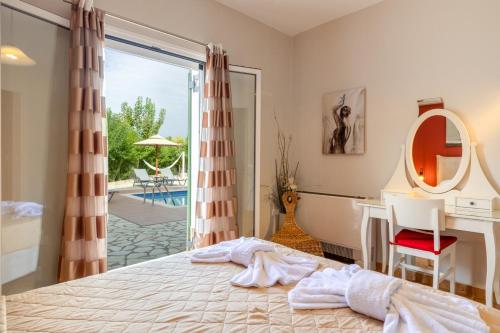 a bedroom with a bed and a desk and a tub at "Villa ANDREAS" in Ayia Evfimia