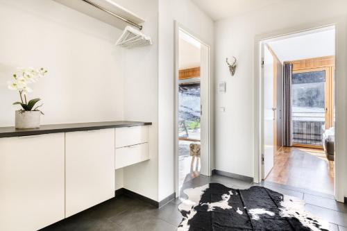 uma cozinha com armários brancos e um balcão preto em Montanara Lodge em Brand