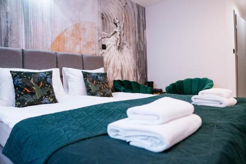 a bedroom with a green bed with towels on it at THE VIEW - WILLA z basenem in Iława