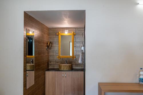 a bathroom with a sink and a mirror at Saavaj Resort in Sasan Gir