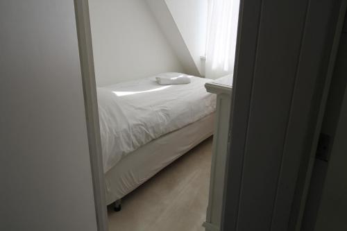 a small bed in a small room with a window at House Akerdijk 5 persons 3 bedrooms in Badhoevedorp