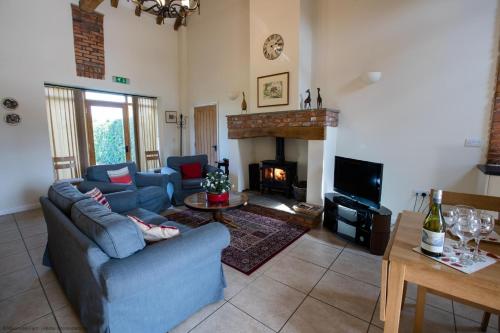 a living room with a blue couch and a fireplace at The Forge in Selby