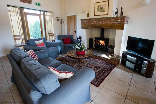 a living room with a couch and a fireplace at The Forge in Selby