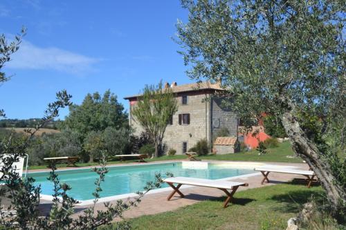a house with a swimming pool in front of a building at Country House Style in Montefiascone