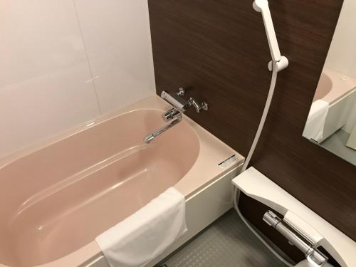 大阪的住宿－Hotel Boti Boti，浴室设有粉红色浴缸和镜子