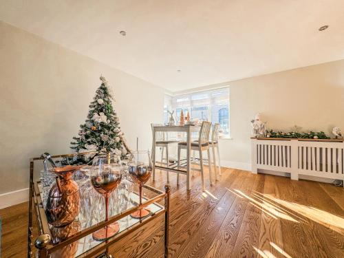 a dining room with a christmas tree and wine glasses at My Richmond London SUPER KING Size Bed in Kew