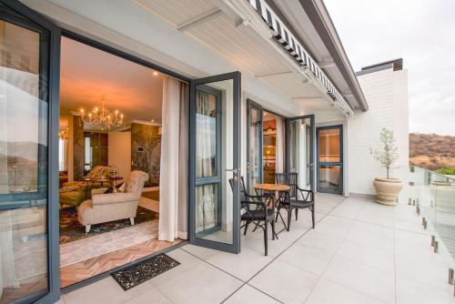 an outdoor patio with glass doors and a dining room at The Weinberg Urban Pod in Windhoek