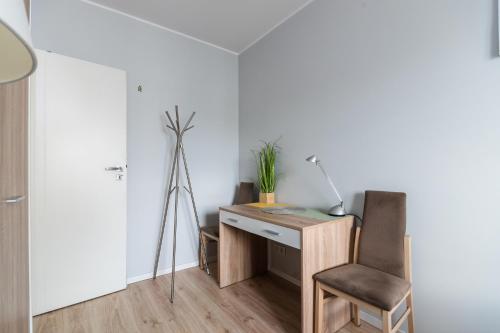 a desk with a chair and a lamp in a room at Jesionowa Standard Apartment in Wrocław