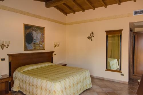 a bedroom with a bed and a mirror at Hotel Quadrifoglio Roma Eur in Mostacciano 