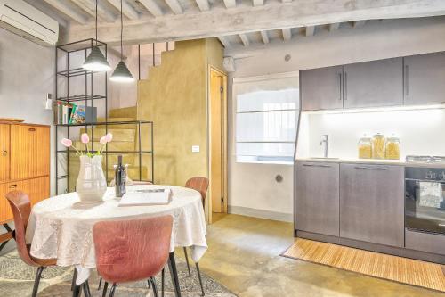 eine Küche mit einem Tisch und einer Blumenvase darauf in der Unterkunft Casa Colonia - Together in Tuscany in Cortona