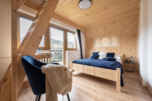 ein Schlafzimmer mit einem blauen Bett in einem Holzhaus in der Unterkunft Domek Zakopane Tatrzański Kącik APARTZAKOP in Zakopane