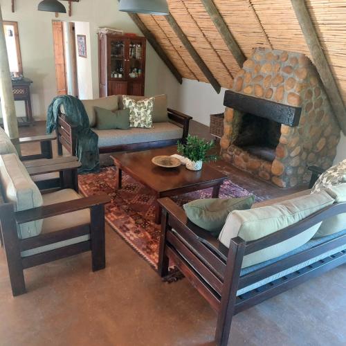 a living room with a couch and a fireplace at Breede Bush Camp in Bakklysdrift
