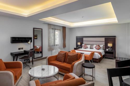 Habitación de hotel con cama y sala de estar. en Best Western Plus The Athena Hotel Kampala, en Kampala