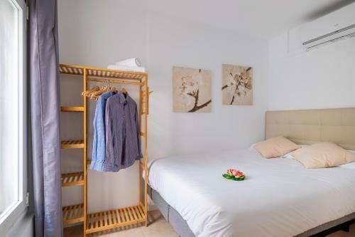 a bedroom with a bed and a rack of clothes at Apartment next to Europa Fira and 20' from Barcelona city center in Hospitalet de Llobregat