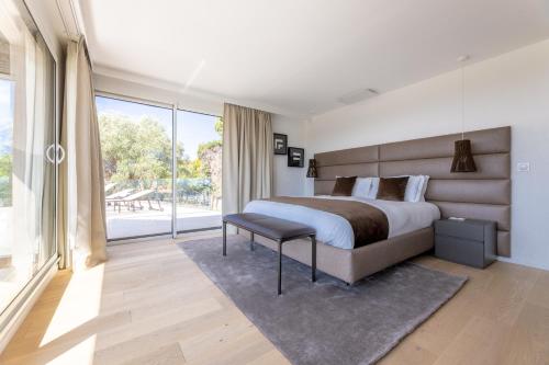 una camera da letto con un letto grande e una grande finestra di Villa Paulina MOUGINS a Mougins