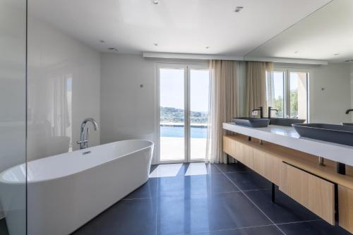 un bagno con tre lavandini e una grande vasca di Villa Paulina MOUGINS a Mougins