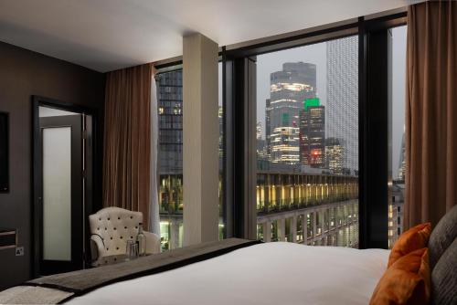 a bedroom with a view of a city skyline at Montcalm Royal London House, London City in London