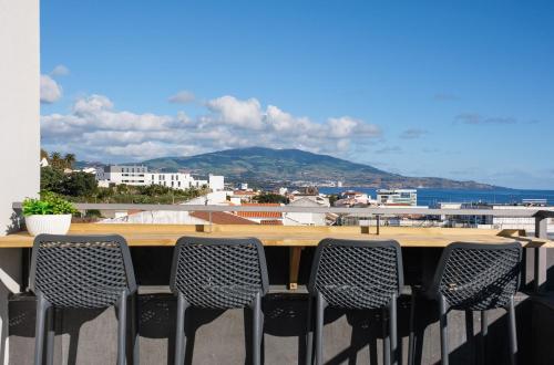 a table and chairs on a balcony with a view of the ocean at Sky PDL in Ponta Delgada