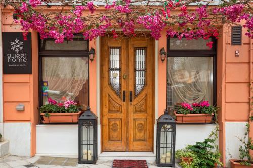 an orange house with a wooden door and flowers at Sweet Home Hotel in Athens