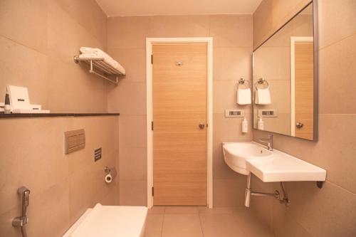 La salle de bains est pourvue d'un lavabo, de toilettes et d'un miroir. dans l'établissement Hotel Star City, à Chennai