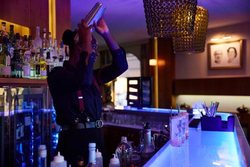 a woman standing at a bar with her hands in the air at A Casa Di Mà in Lumio